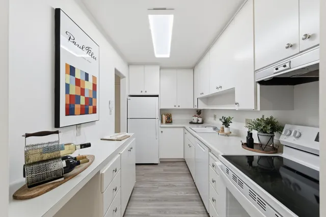 a kitchen with stainless steel appliances a white stove top oven and cabinets