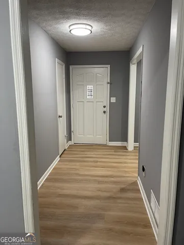 a view of a hallway with wooden floor