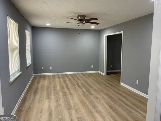an empty room with a window and a ceiling fan