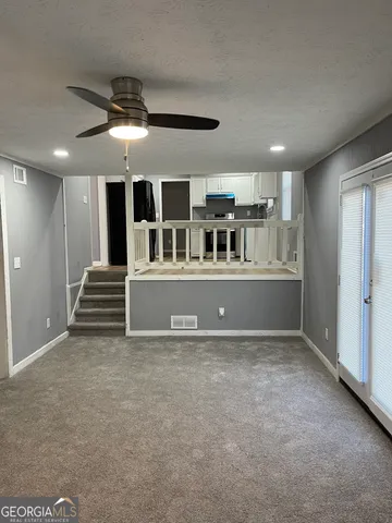 a view of a big room with kitchen and windows