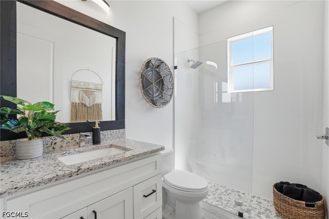 4635 Northwest 32nd Street Cape Coral, FL 33993 - Photo 15 of 30 a bathroom with a granite countertop sink a toilet and mirror
