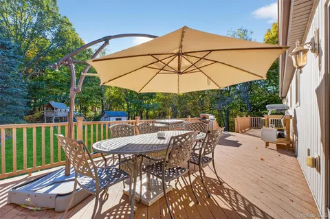 a view of a patio with a table and chairs under an umbrella