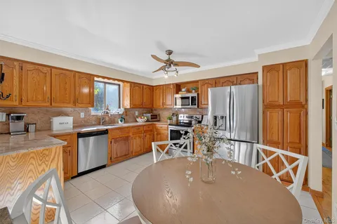 a kitchen with sink a refrigerator and chairs