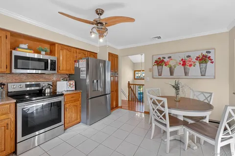 a kitchen with stainless steel appliances a table chairs refrigerator and microwave