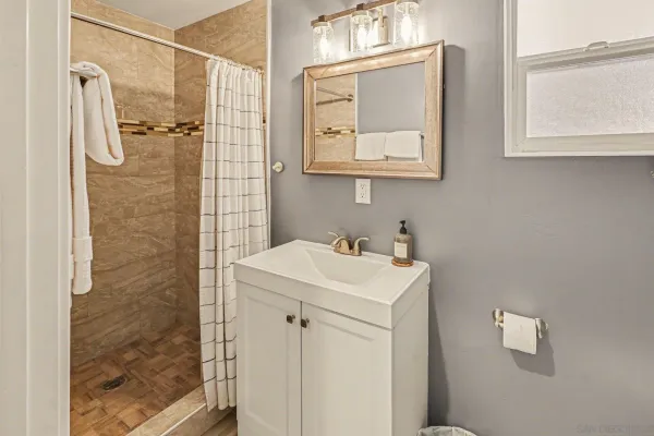 a bathroom with a sink a mirror and shower
