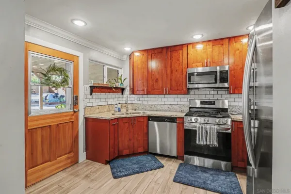 a kitchen with stainless steel appliances granite countertop a stove a sink and a refrigerator