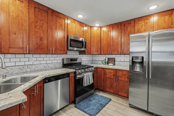 a kitchen with stainless steel appliances granite countertop a refrigerator stove a sink and dishwasher