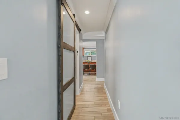 a view of a hallway with wooden floor and staircase
