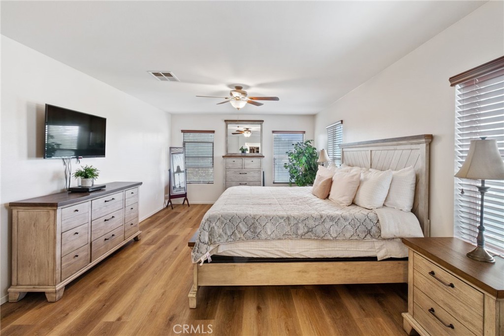 641 Amaranta Avenue Perris, CA 92571 - Photo 13 of 31 a spacious bedroom with a bed and a flat screen tv