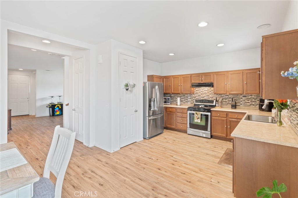641 Amaranta Avenue Perris, CA 92571 - Photo 5 of 31 a kitchen with stainless steel appliances kitchen island granite countertop a refrigerator and stove