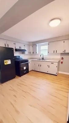a kitchen with stainless steel appliances cabinets and wooden floor