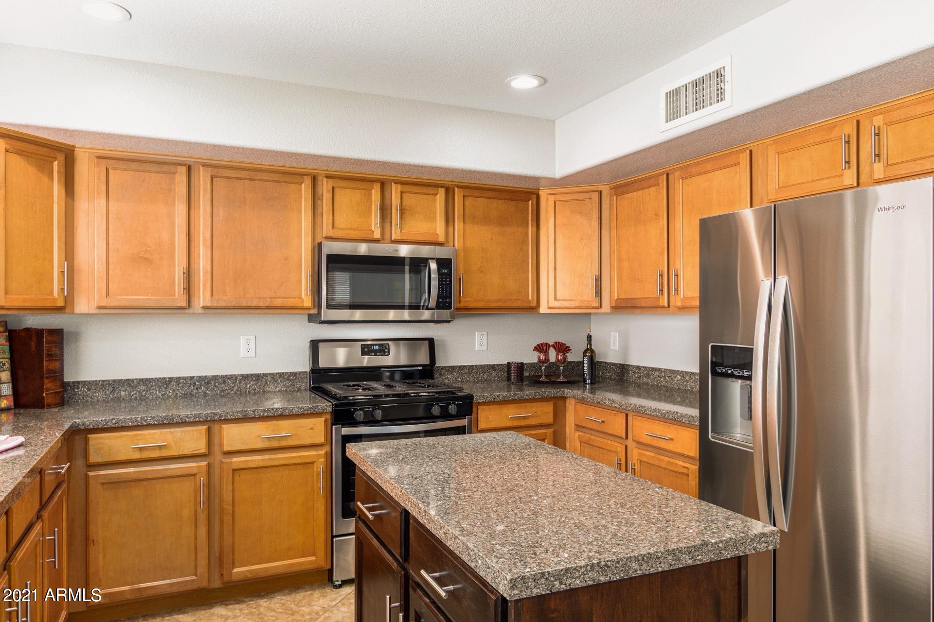 2438 West Running Deer Trail Phoenix, AZ 85085 - Photo 11 of 28 a kitchen with stainless steel appliances granite countertop a refrigerator a stove top oven a sink and dishwasher
