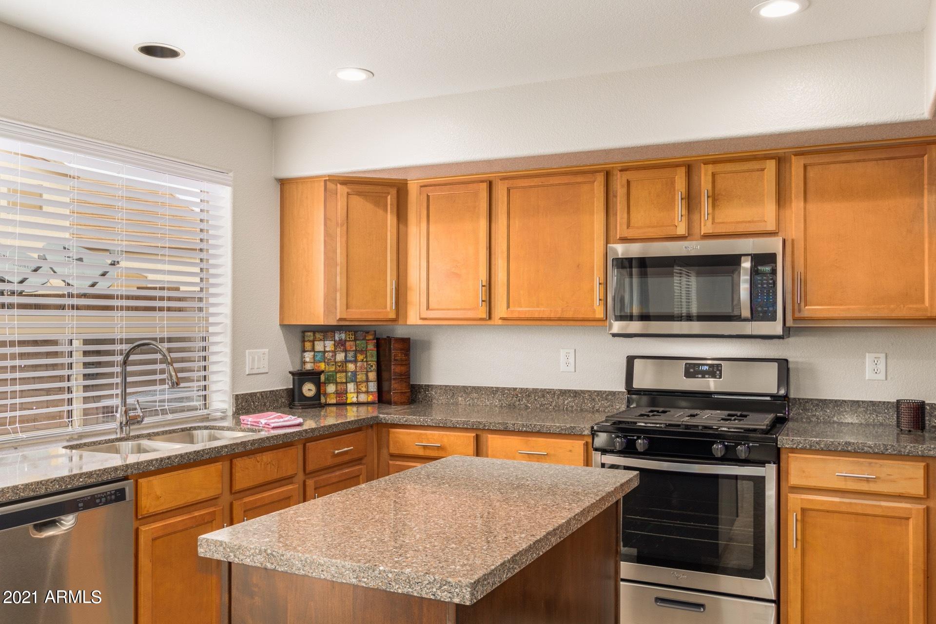 2438 West Running Deer Trail Phoenix, AZ 85085 - Photo 12 of 28 a kitchen with stainless steel appliances granite countertop a stove a sink and a microwave