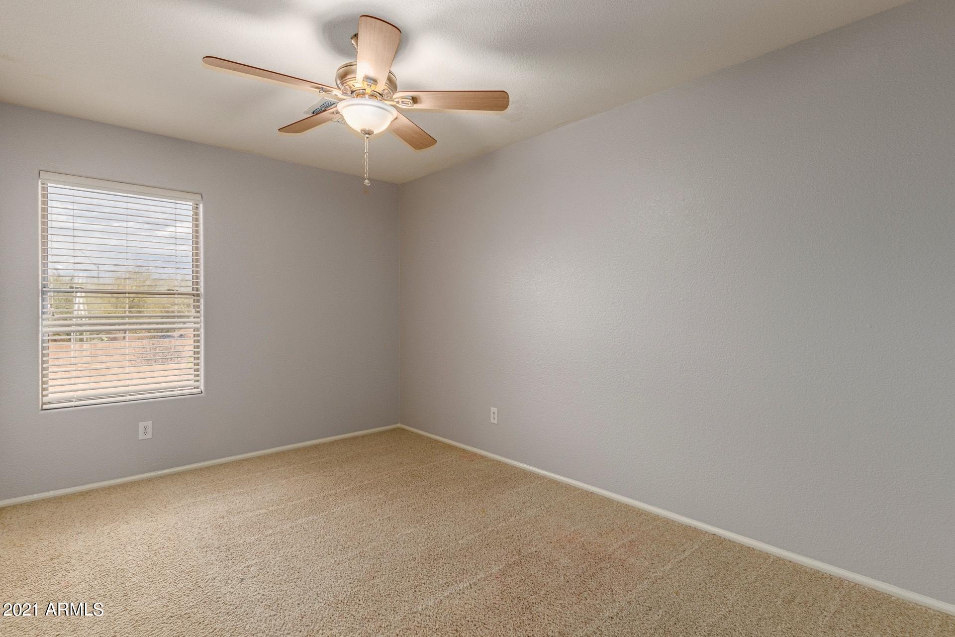 2438 West Running Deer Trail Phoenix, AZ 85085 - Photo 18 of 28 an empty room with a window and a chandelier fan