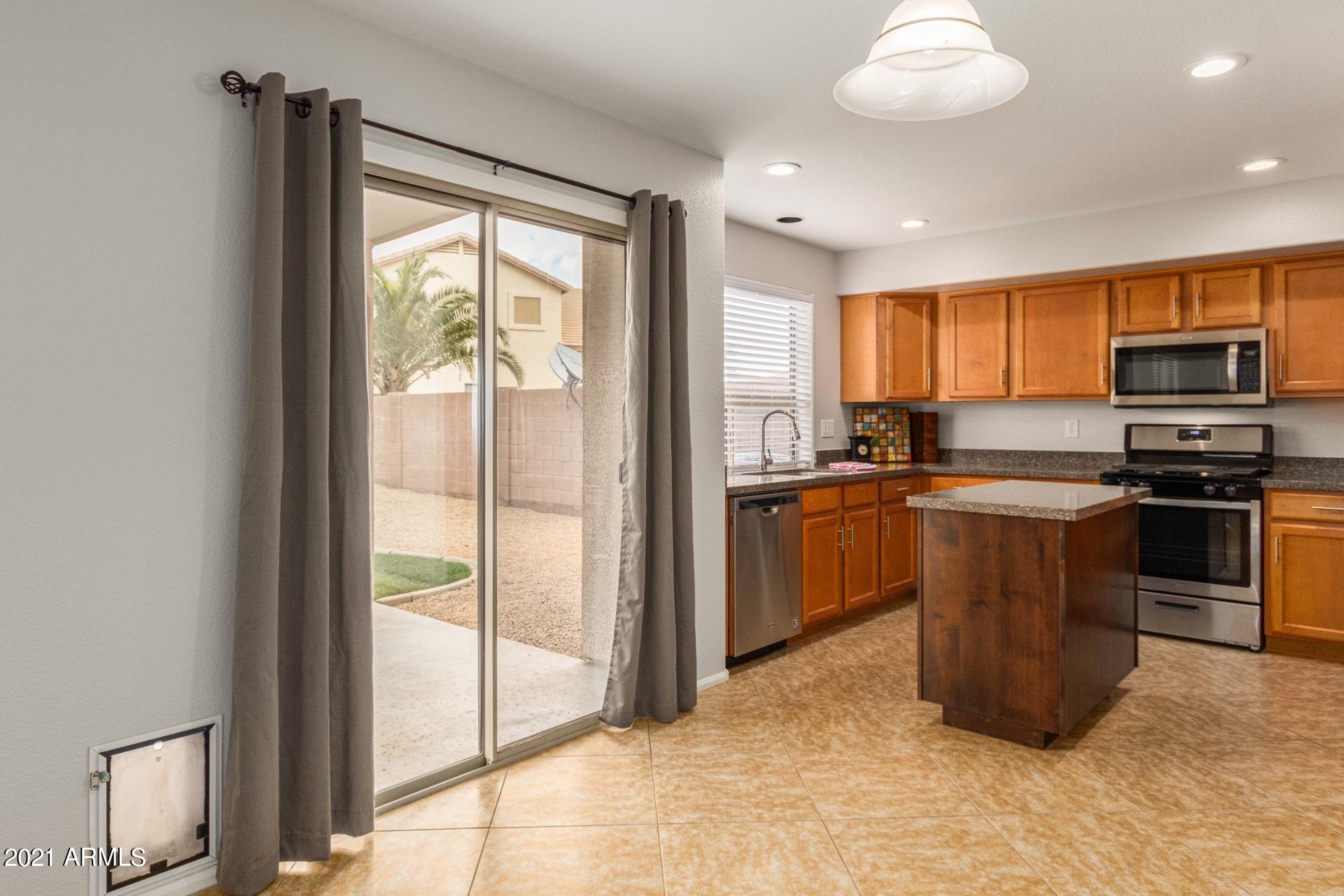 2438 West Running Deer Trail Phoenix, AZ 85085 - Photo 9 of 28 a kitchen with a stove a sink and a microwave