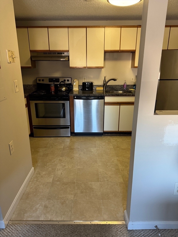 35 Prospect Street, Unit 301 Woburn, MA 01801 - Photo 5 of 6 a kitchen with stainless steel appliances a stove a sink and a refrigerator