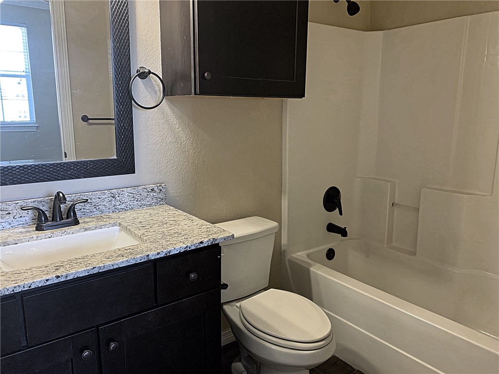 301 Southwest Parkway, Unit 351 College Station, TX 77840 - Photo 9 of 10 a bathroom with a granite countertop sink toilet and shower