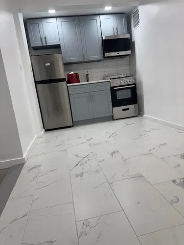 a kitchen with granite countertop a stove a microwave and a refrigerator