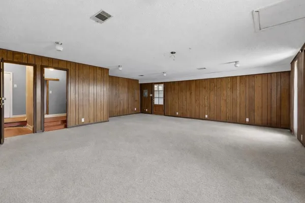 a view of a livingroom with wooden floor fireplace and windows