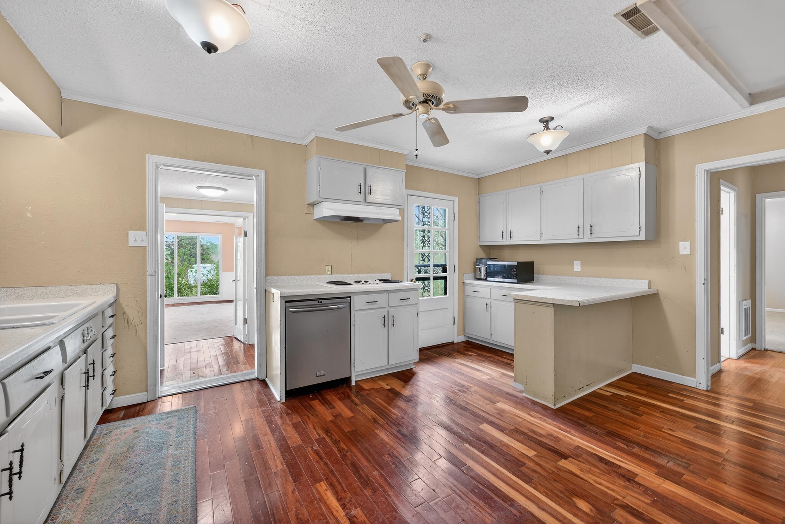 700 North Reid Hooker Road Eads, TN 38028 - Photo 12 of 20 Kitchen with dark wood-style floors, light countertops, a textured ceiling, stainless steel appliances, and crown molding
