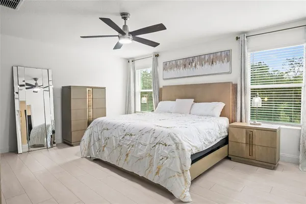 a spacious bedroom with a bed and a large window