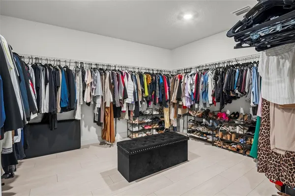 a view of walk in closet with clothes