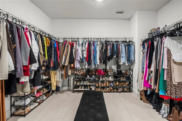 a view of walk in closet with clothes