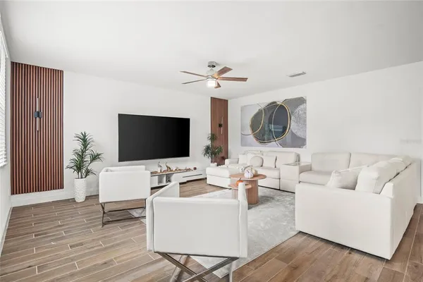 a living room with furniture a flat screen tv and a window