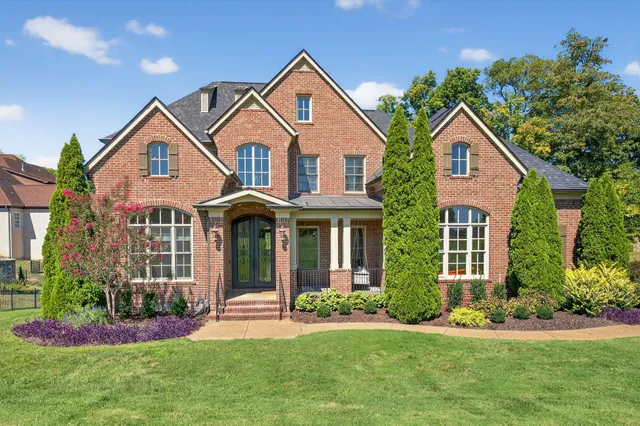 a kitchen with granite countertop a stove a sink a kitchen island with chairs and wooden floor