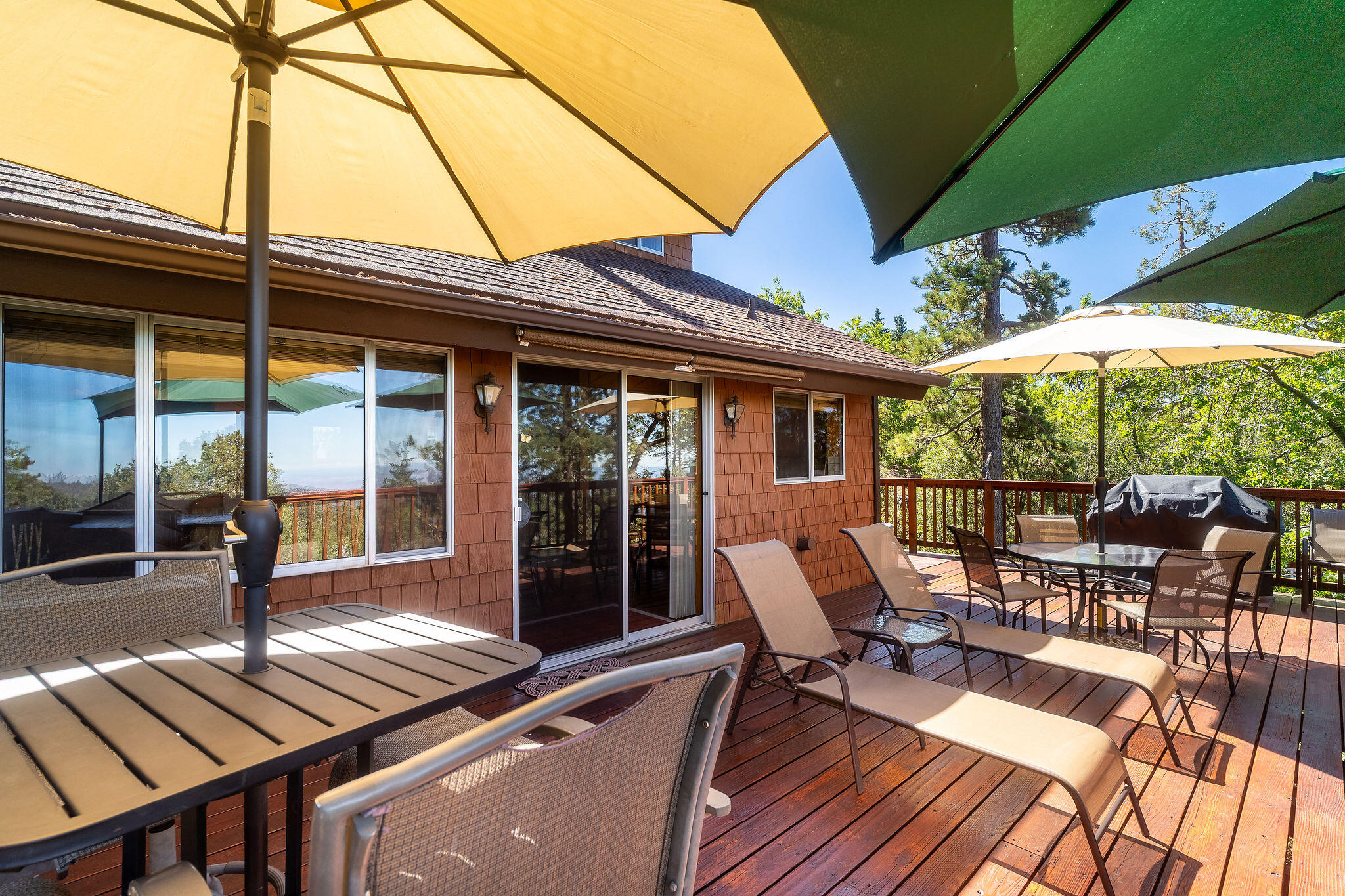 24675 Rocky Point Road Idyllwild, CA 92549 - Photo 30 of 64 a view of a patio with table and chairs under an umbrella