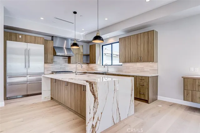 a kitchen with stainless steel appliances granite countertop a sink a oven and a refrigerator