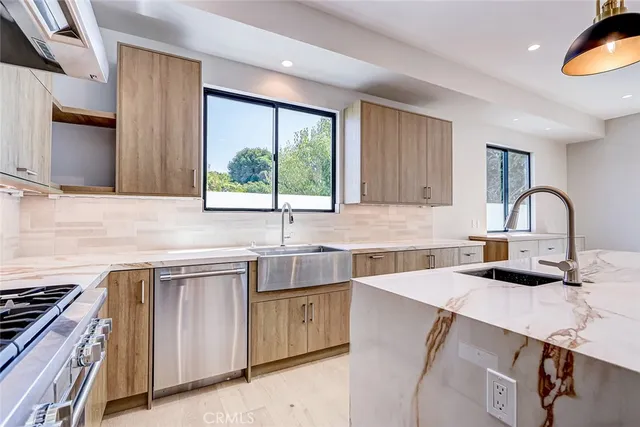 a kitchen with a sink a stove and cabinets