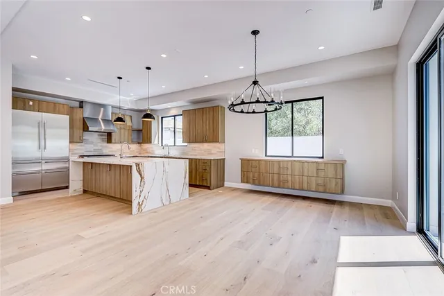 a kitchen with stainless steel appliances a sink window and cabinets