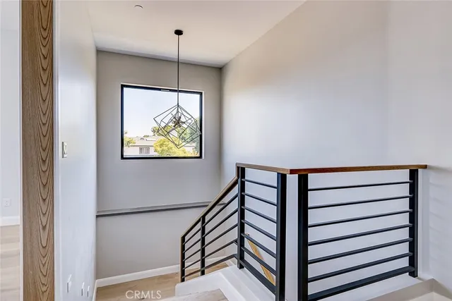 a view of a hallway with wooden floor and a window