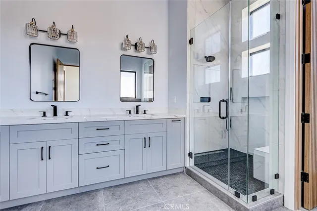 a bathroom with double vanity and a shower