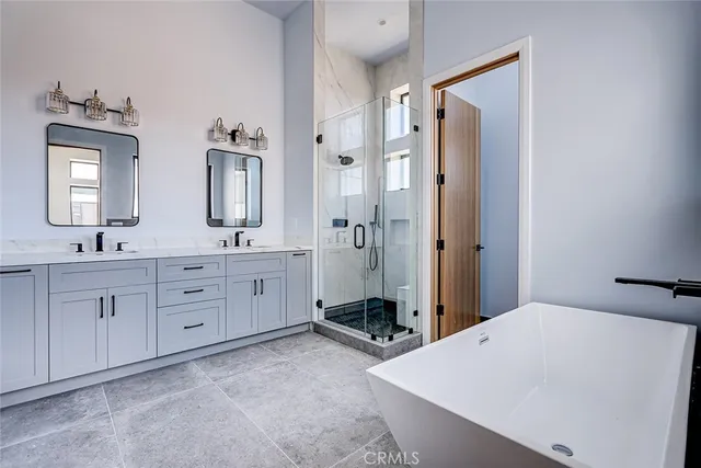 a spacious bathroom with double vanity sinks a mirror and a shower