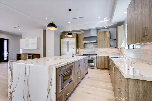 a kitchen with stainless steel appliances granite countertop a sink a stove and a refrigerator