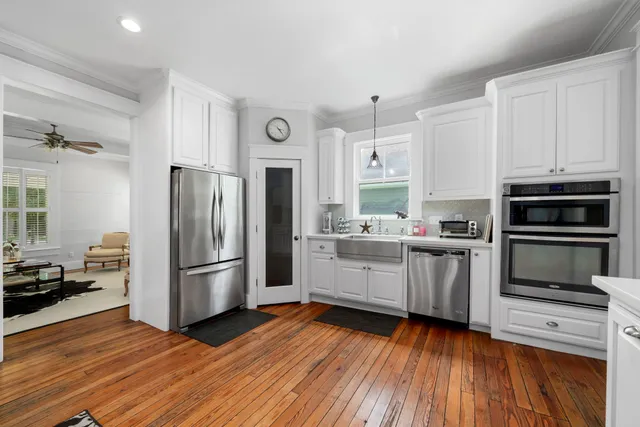 a kitchen with granite countertop a refrigerator and a stove top oven