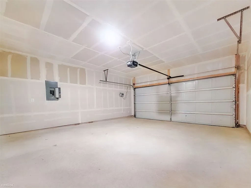 419 Sickle Loop Kyle, TX 78640 - Photo 32 of 35 A spacious, newly finished garage offers ample parking and storage with an automatic door opener.
