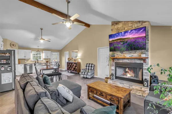 a living room with furniture a flat screen tv and a fireplace