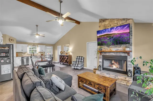 a living room with furniture a flat screen tv and a fireplace