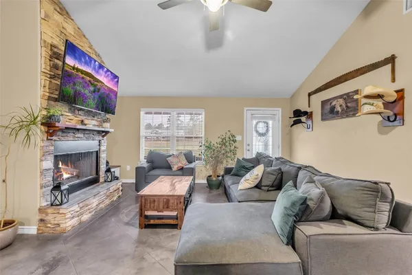 a living room with furniture a flat screen tv and a fireplace