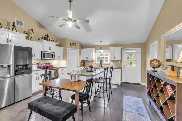 a view of a dining room with furniture and a kitchen