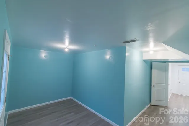 a view of hallway with closet and wooden floor