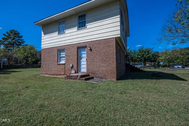 a view of a house with backyard and a tree