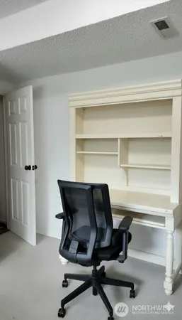 a view of a workspace with furniture and a window