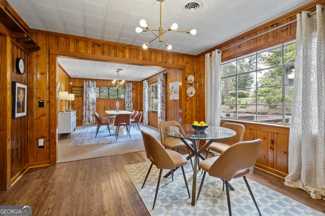 a dining room with furniture a chandelier and wooden floor