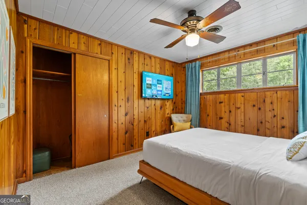 a bed sitting in a bedroom next to a window