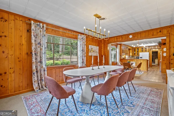 a dining room with furniture a chandelier and wooden floor