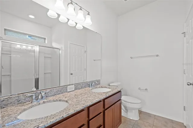 a bathroom with a granite countertop sink a toilet and a mirror